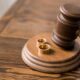 close-up view of judge hammer and wedding rings on wooden table, divorce concept
