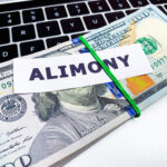 Concept of paying alimony, stack of money on the table.