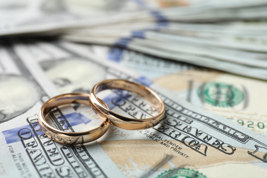 two wedding rings on money bills