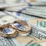 two wedding rings on money bills